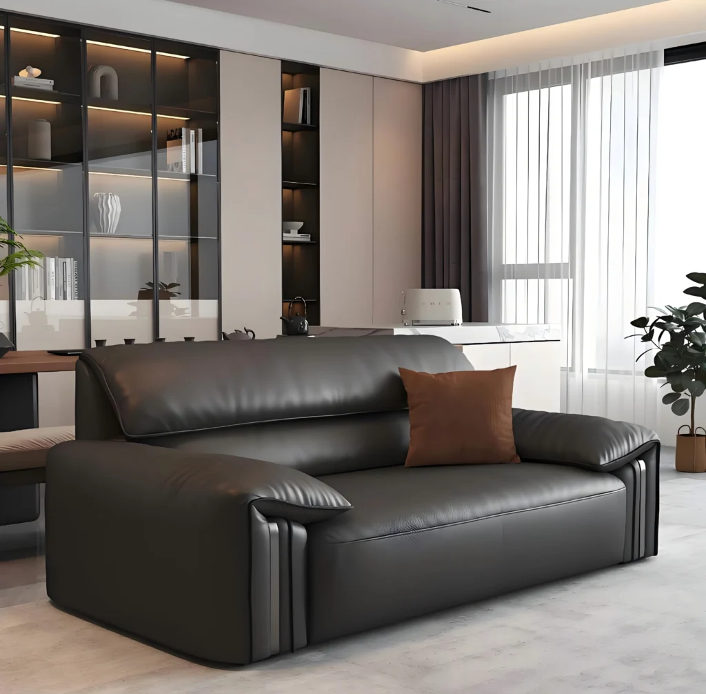 Modern black leather sofa placed near a large window, illustrating the importance of UV protection and environmental control in leather furniture maintenance.